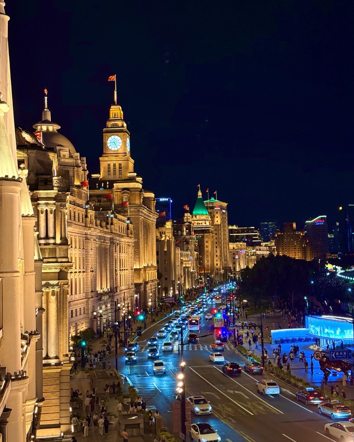 Evening traffic and pedestrians move along Shanghai’s illuminated Bund